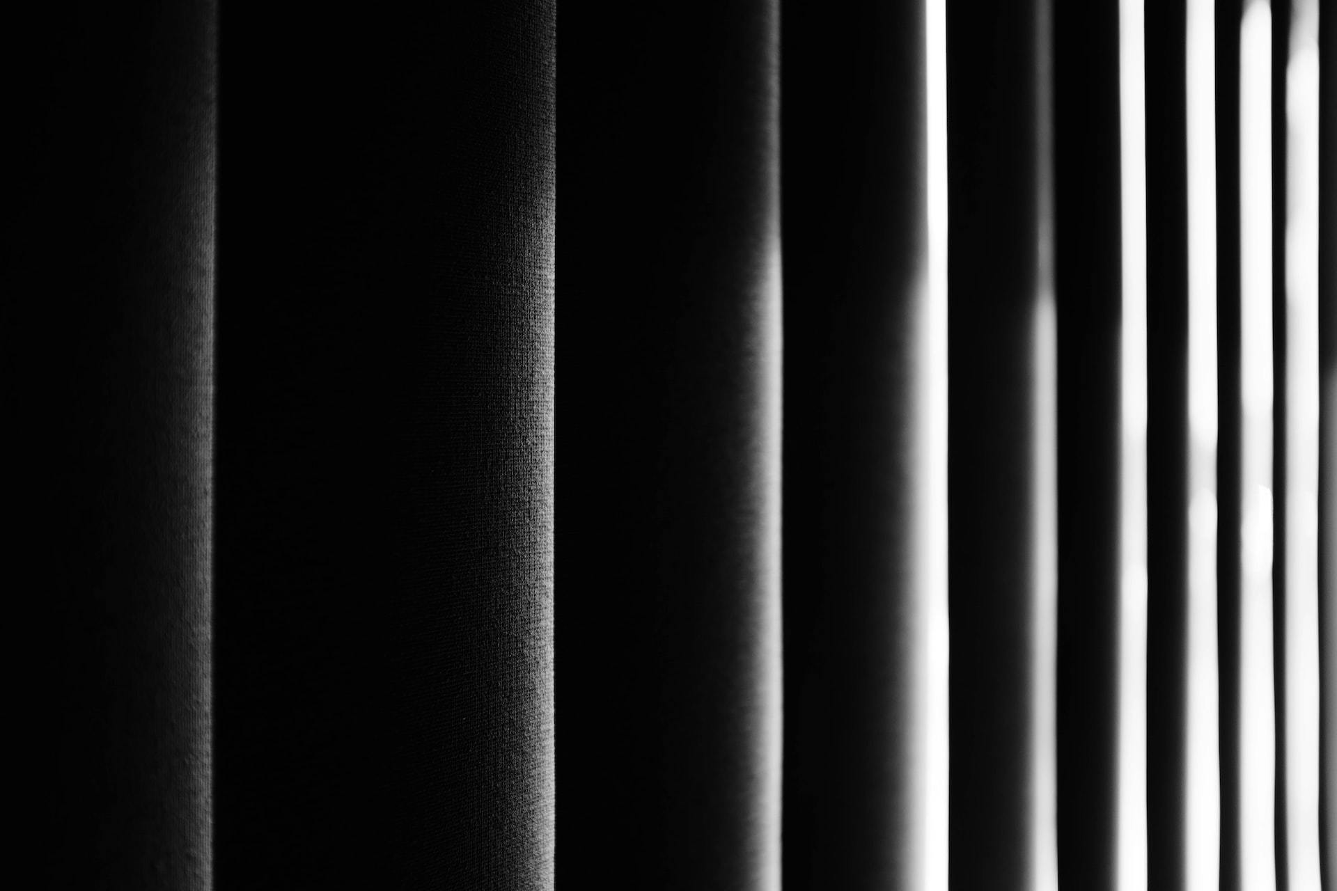 A close-up shot of the vertical bars of a prison cell