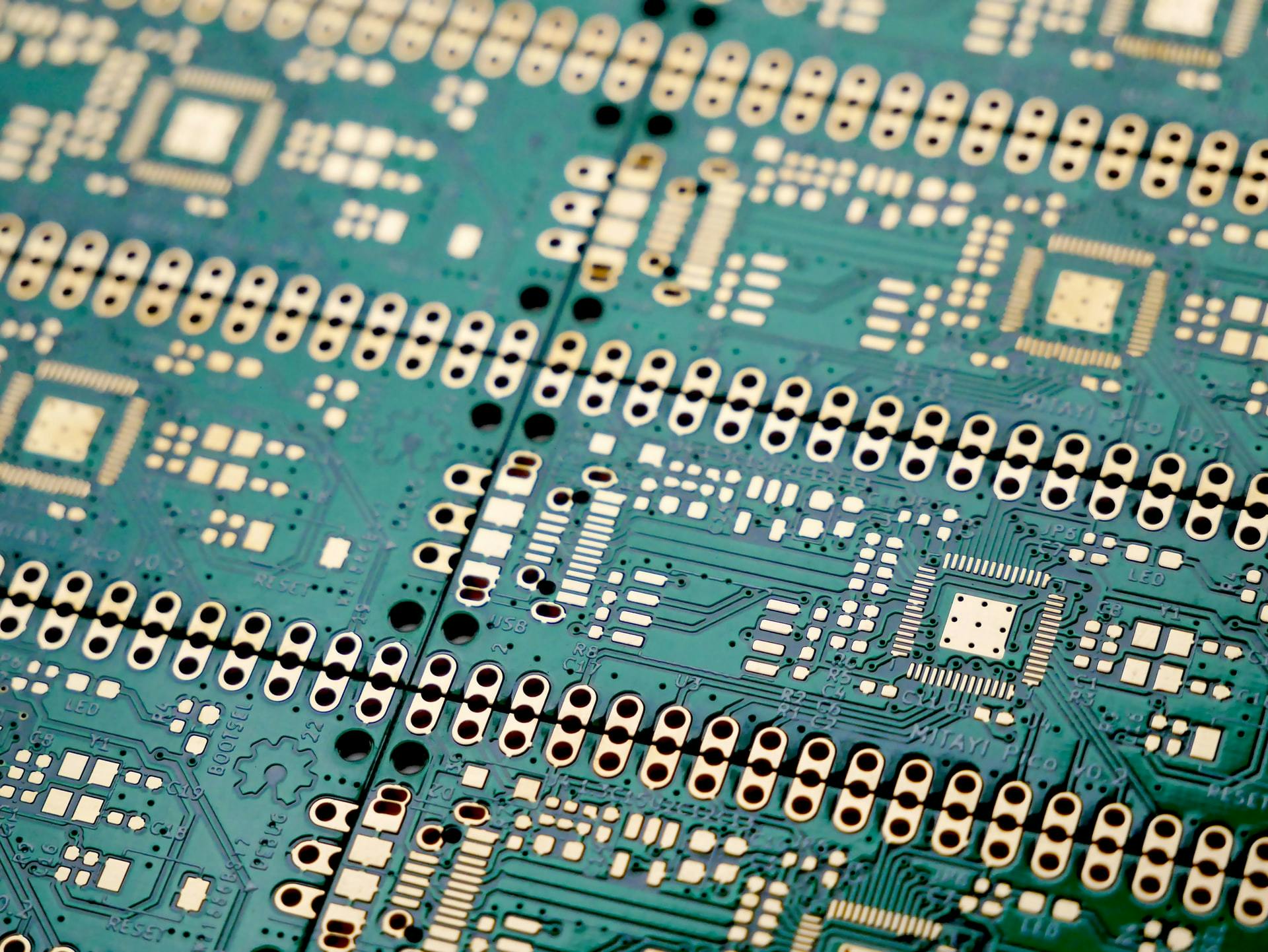 A close-up shot of computer circuitry, where the board is green and various metallic elements appear yellowish-gold