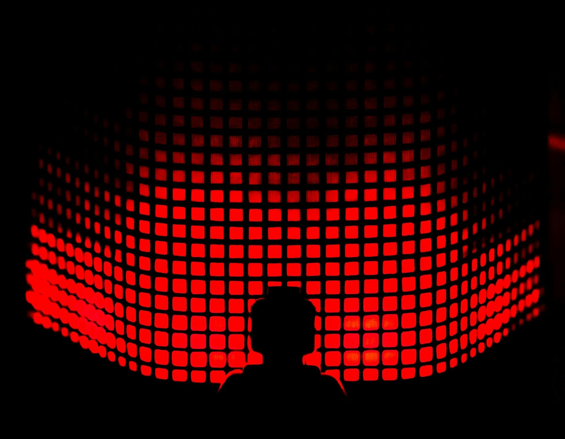 An abstract black silhouette of a person in front of a grid of red squares